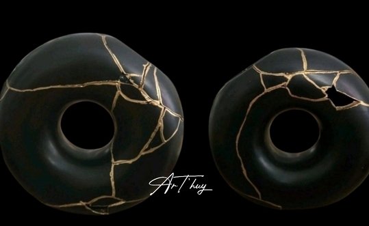 Deux sculptures circulaires noires réparées à l’or selon la technique du kintsugi au Luxembourg.