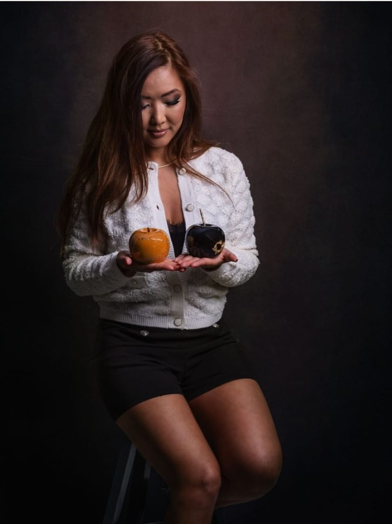 Artiste tenant deux pommes en céramique restaurées selon la technique du kintsugi au Luxembourg.