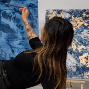 Thuy Gattaux peignant une toile bleue – Artiste kintsugi ArThuy Luxembourg.