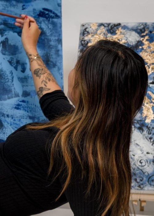 Thuy Gattaux peignant une toile bleue – Artiste kintsugi ArThuy Luxembourg.