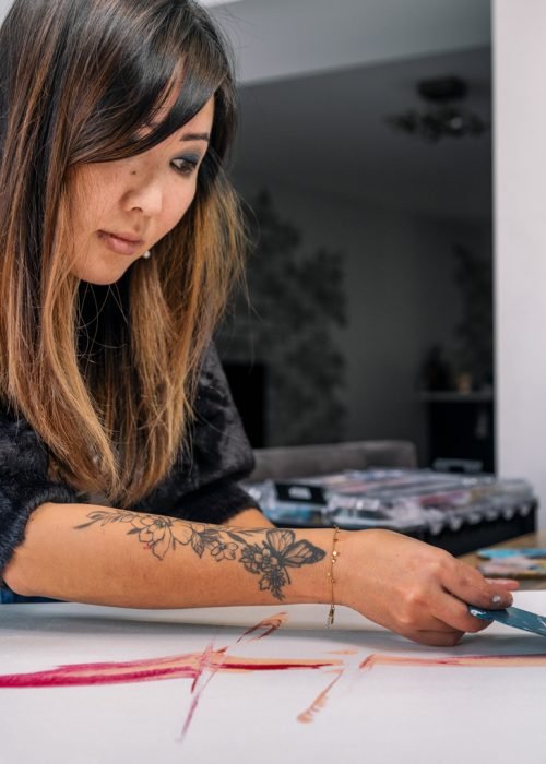 Thuy Gattaux, artiste ArThuy, en train de créer une œuvre dans son atelier au Luxembourg.